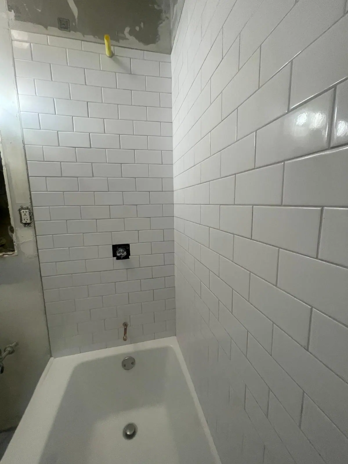 Tub surround in large white glossy subway tile